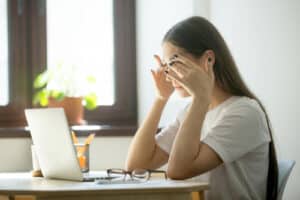 woman holding eyes after working on computer